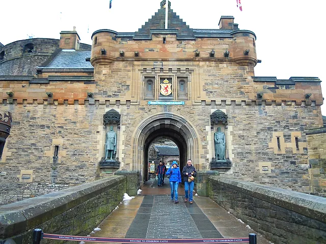 The gatehouse entrance to Edinburgh Castle from the Esplanade, with the royal arms above the arch and a statue in a niche on each side