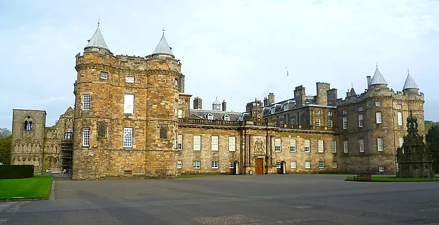 The Palace of Holyroodhouse: the sandstone front with its two towers topped by conical turrets, seen across the forecourt